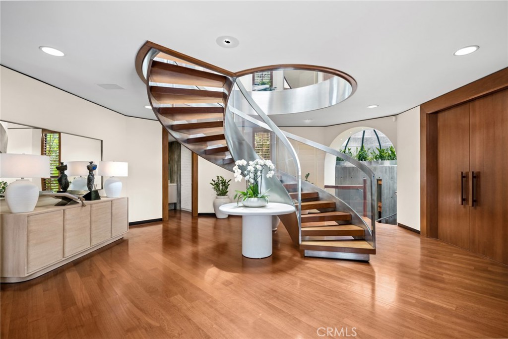Spiral staircase rising through the foyer at 100 Rockledge Road, Laguna Beach