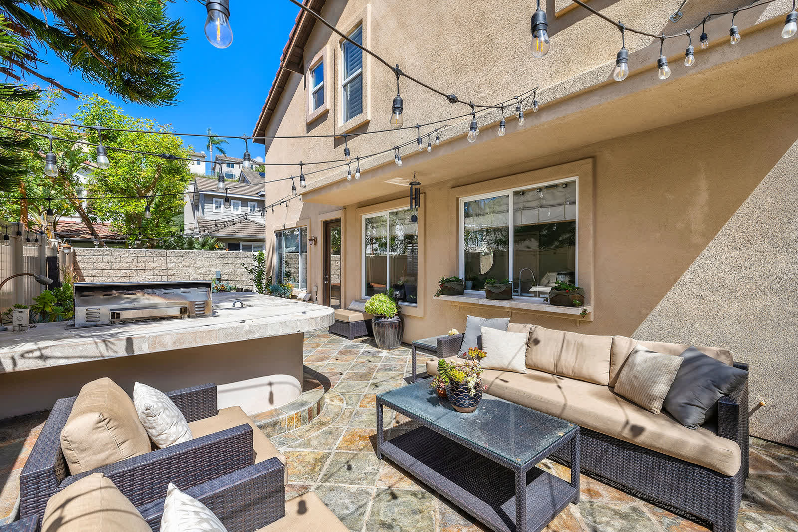 Built-in barbecue and patio seating under string lights at 5 Lyon Ridge, Aliso Viejo