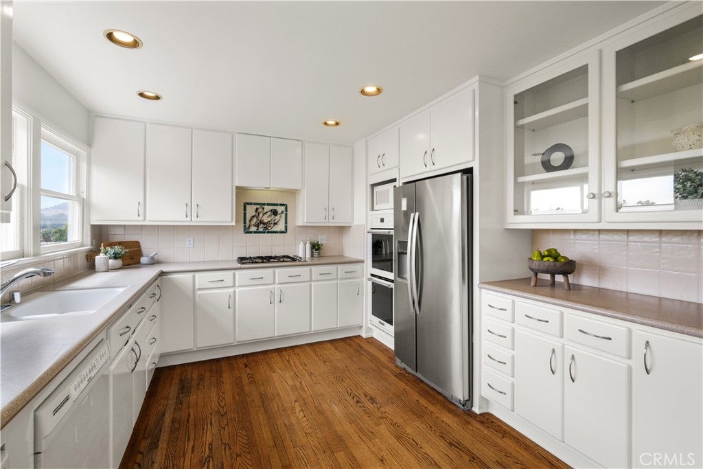 White kitchen with glass-front upper cabinets at 499 Legion, Laguna Beach White kitchen with glass-front upper cabinets at 499 Legion, Laguna Beach