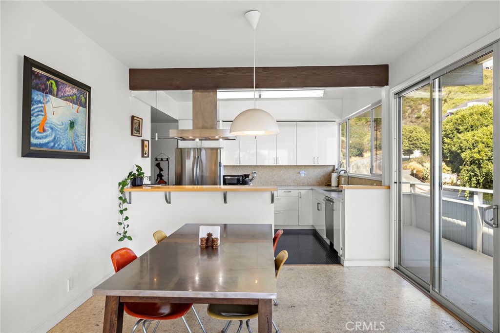 Dining table beside the kitchen and sliding doors to a deck at 888 Summit Drive, Laguna Beach