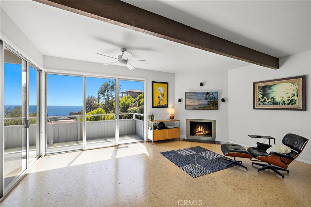 Living room with a fireplace and sliding glass doors to a deck at 888 Summit Drive, Laguna Beach